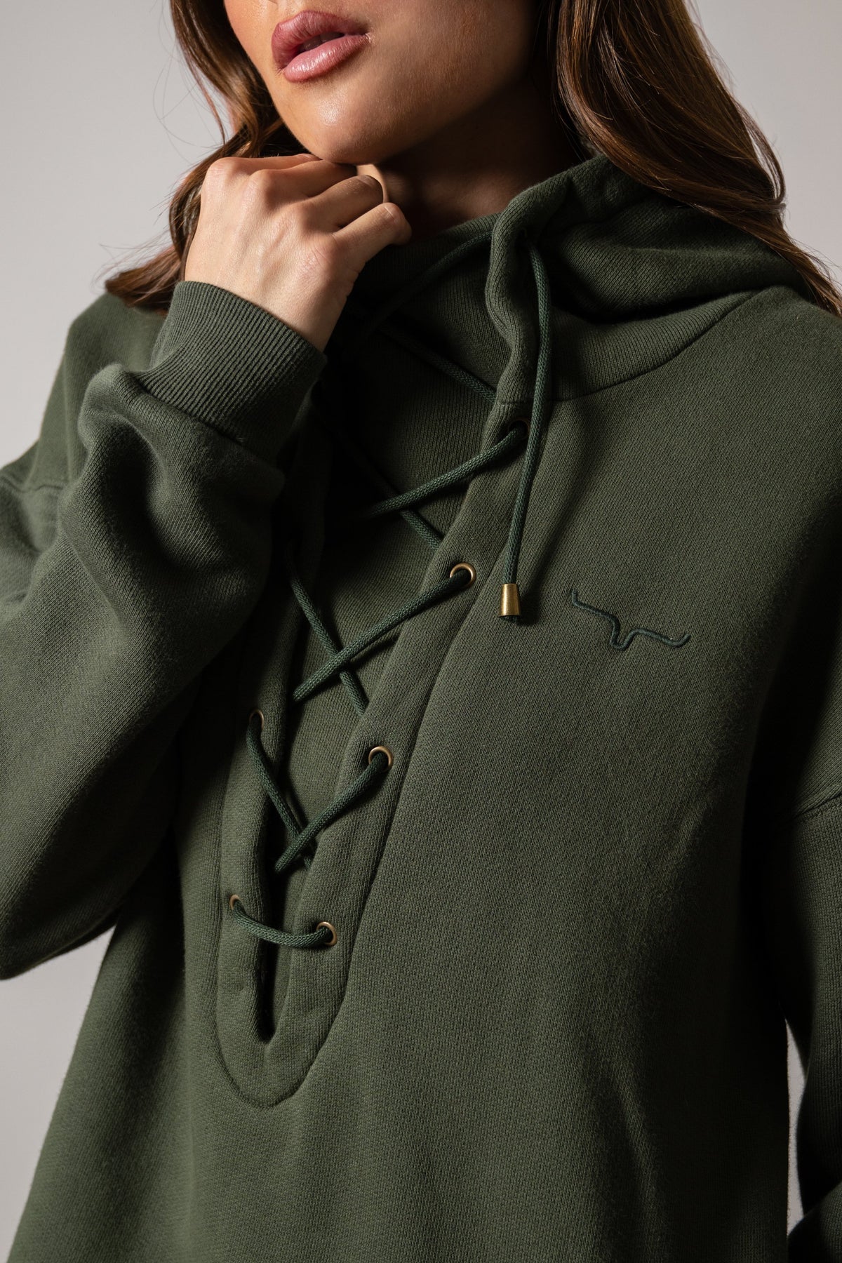 Kimes Ranch Pippi dark olive hoodie with lace-up neckline and Kimes Ranch logo embroidered on the left chest