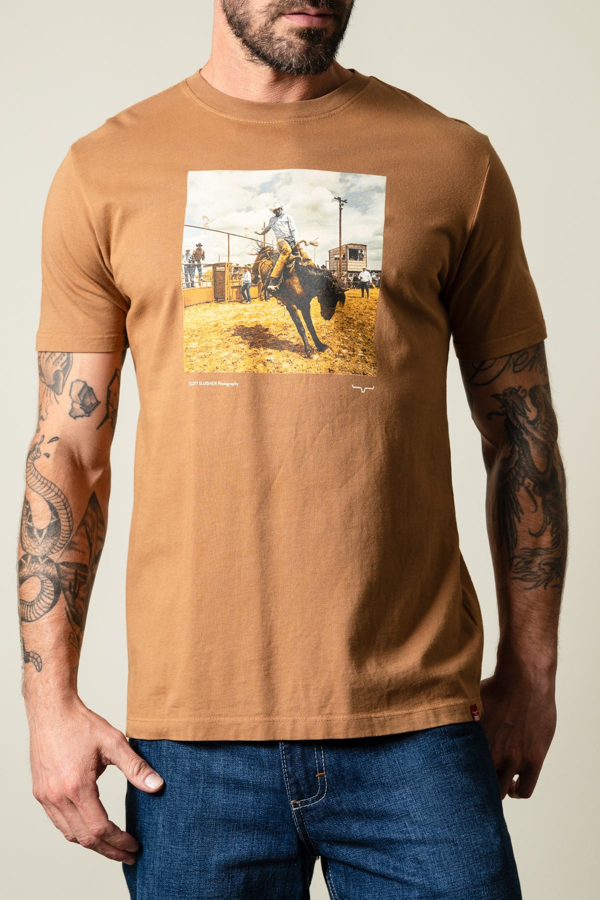 Kimes Ranch Tobacco SS Classic Event tee featuring a rodeo bull rider graphic with 'SCOTT SLUSHER Photography text