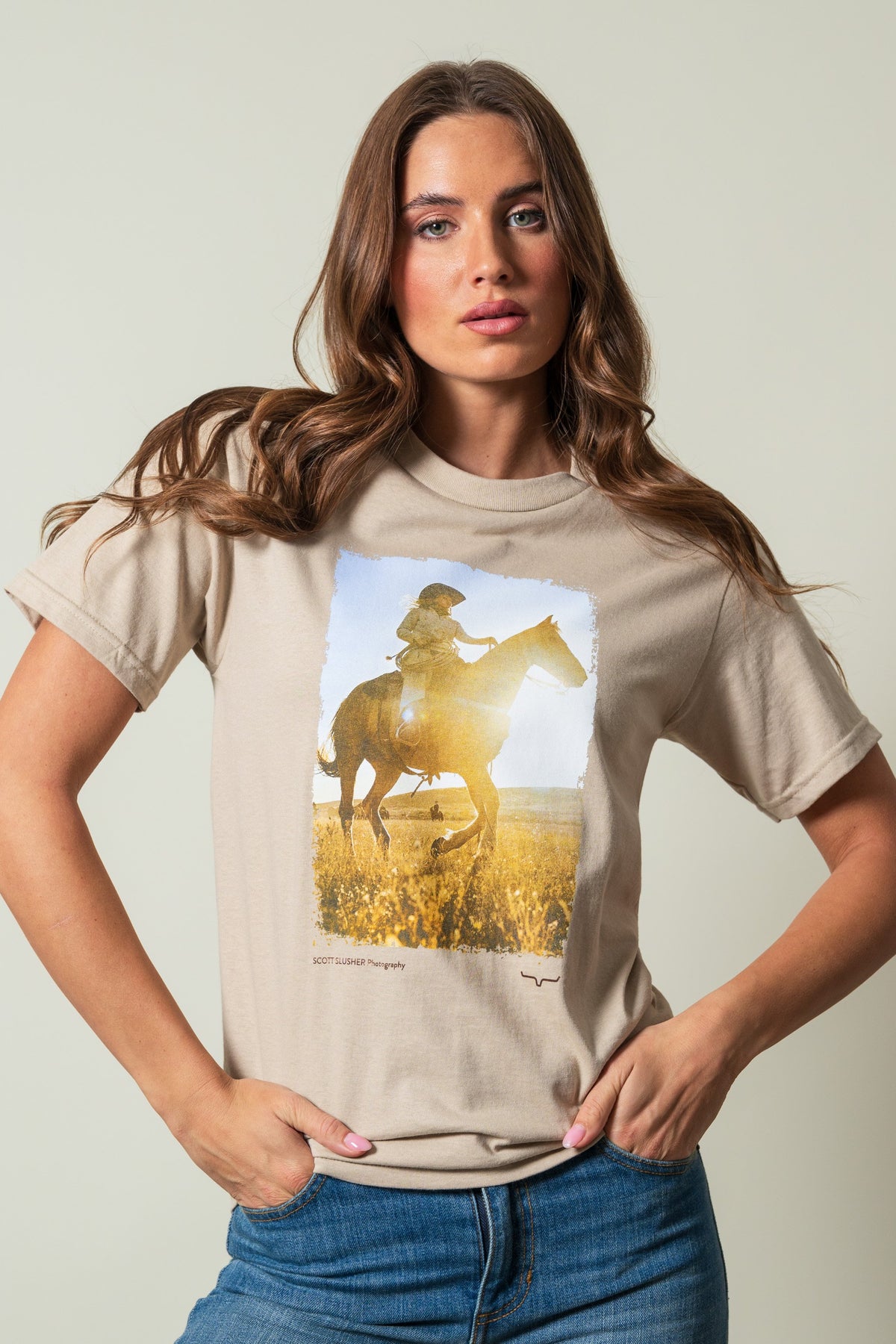 Kimes Ranch SS Riding Sunshine Sand t-shirt, featuring a graphic of a rider on a horse in a field