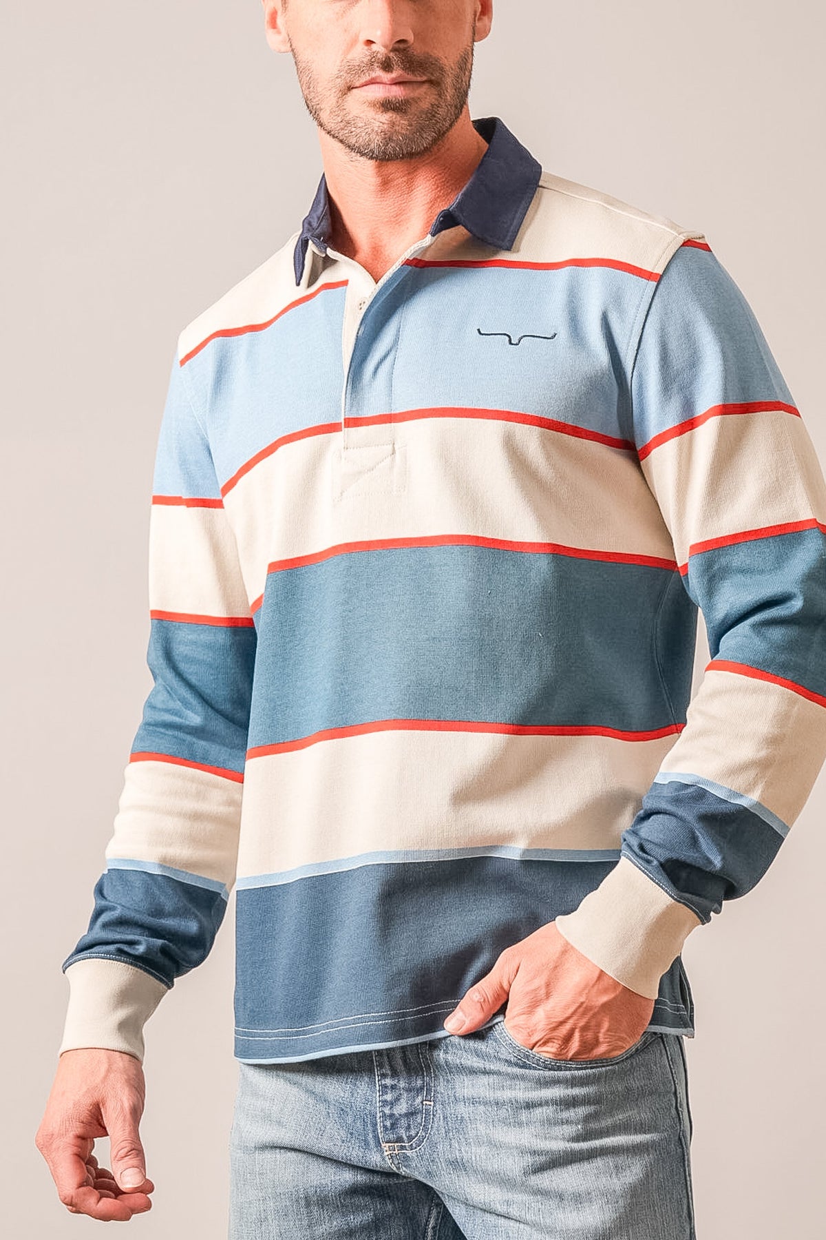 Kimes Ranch York striped polo in mid blue with navy collar, orange accents, and Kimes Ranch logo