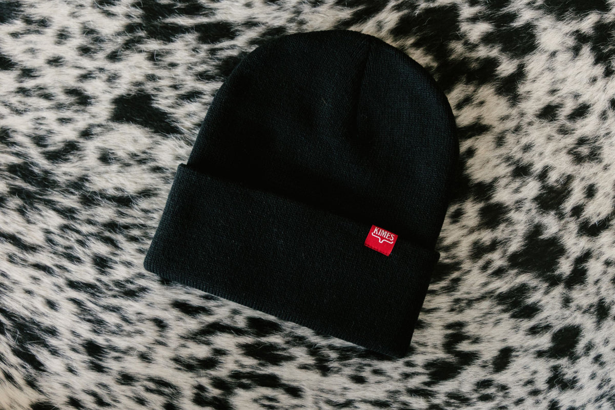 Kimes Ranch KR Clipped Hat in Black, close-up, with a red woven logo patch on the folded cuff