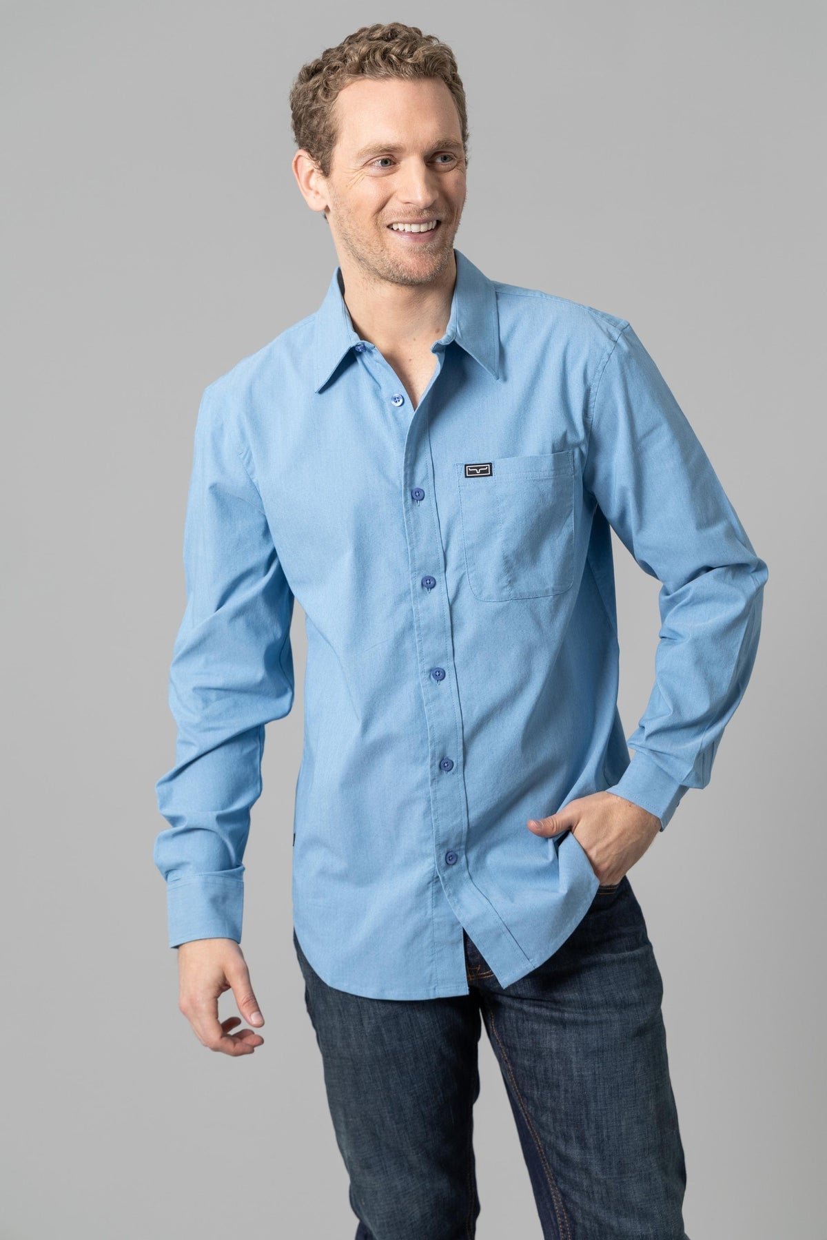 Kimes Ranch Linville Long Sleeve Dress Shirt in Mid Blue with a chest pocket and logo patch