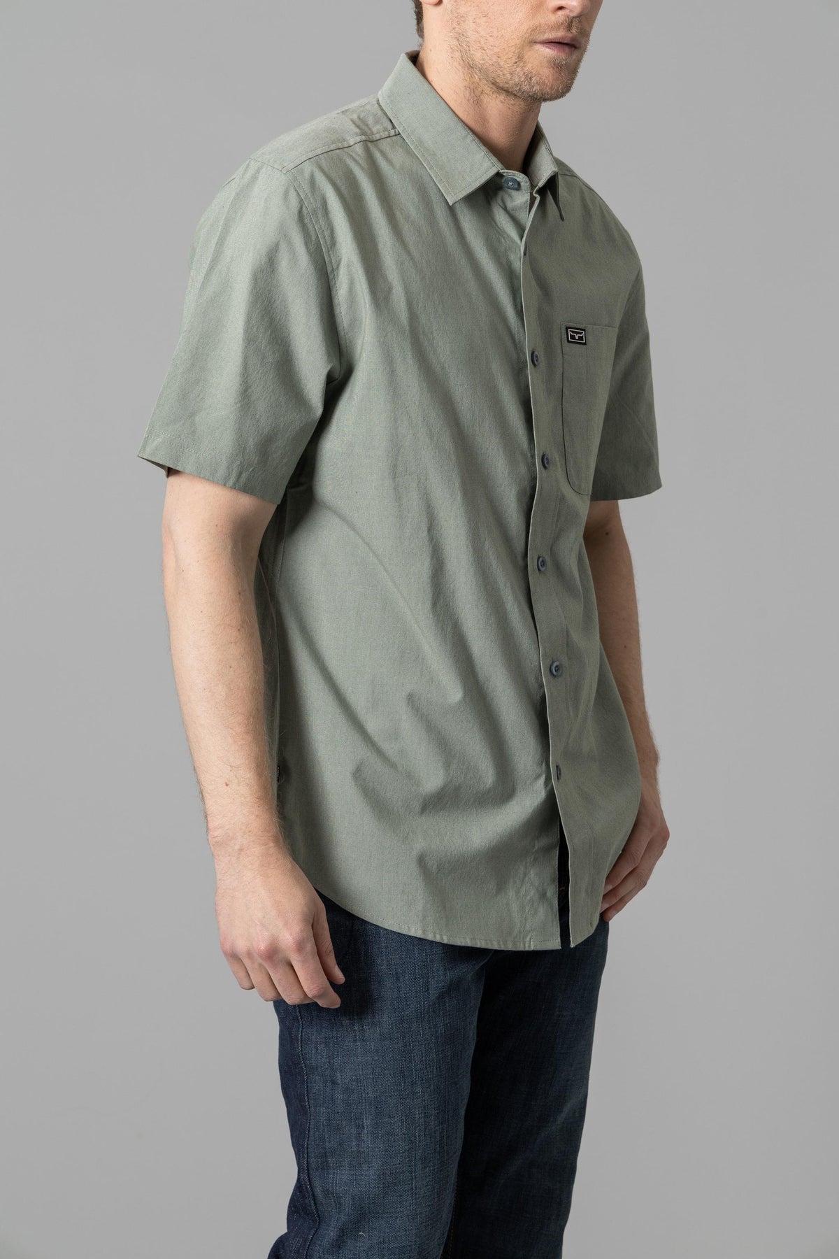 Kimes Ranch Linville Short Sleeve Dress Shirt in Grey Sage, side view, with a chest pocket and logo patch