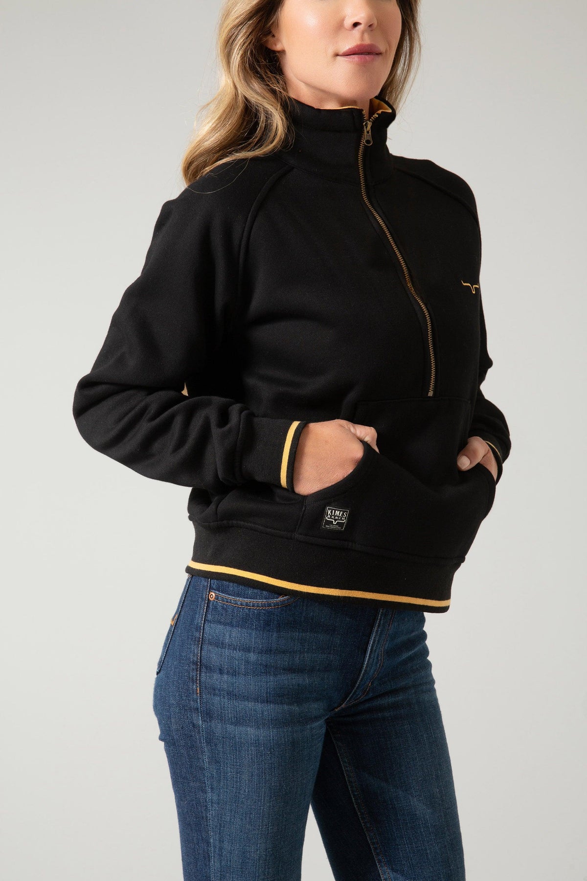 Kimes Ranch Malta Cropped Quarter Zip Sweatshirt in Black, side view, with gold zipper and trim