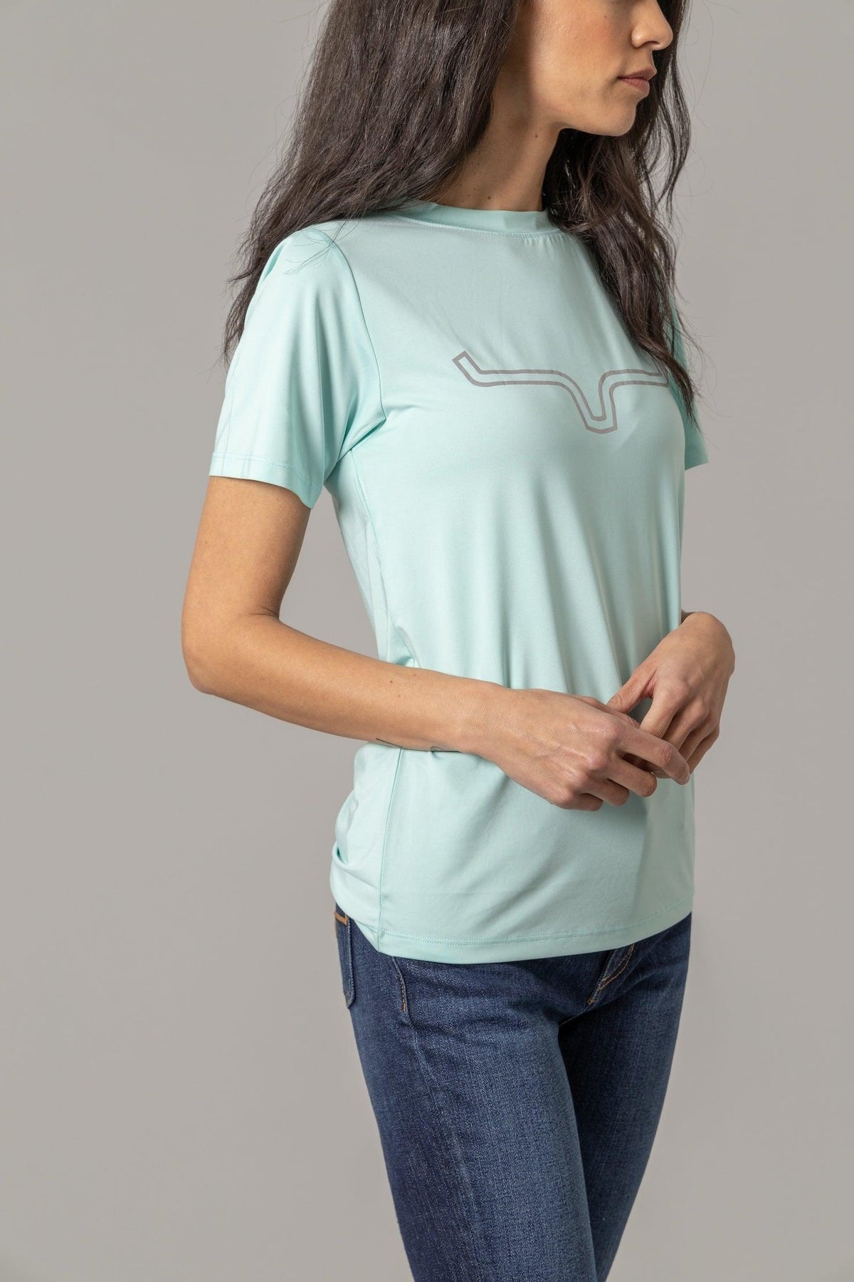 Kimes Ranch Ladies Outlier Tech Tee Shirt in Aqua, side view, with a grey logo on the chest