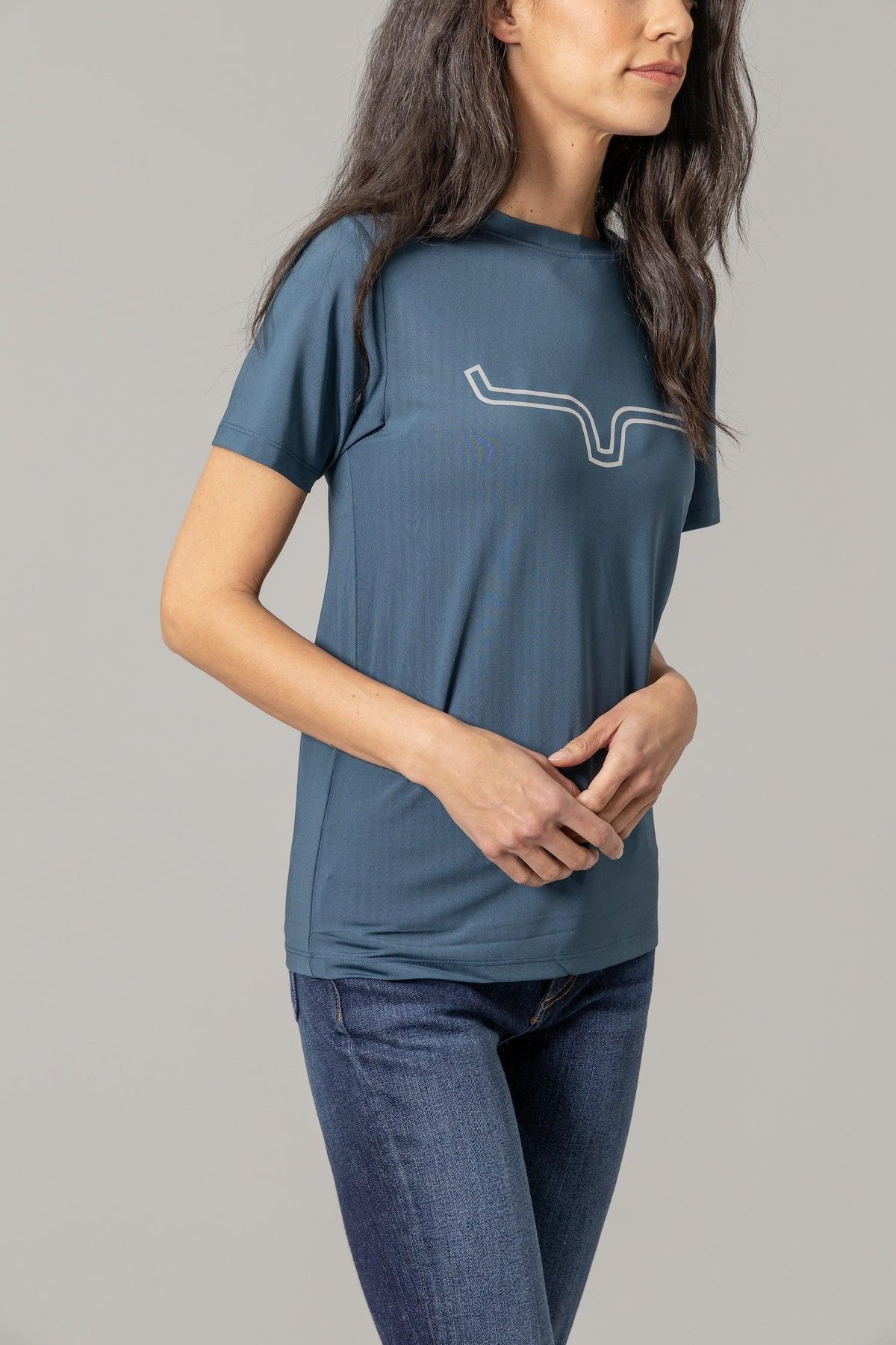 Kimes Ranch Ladies Outlier Tech Tee Shirt in Major Blue, side view, with a white outline steer logo on the chest