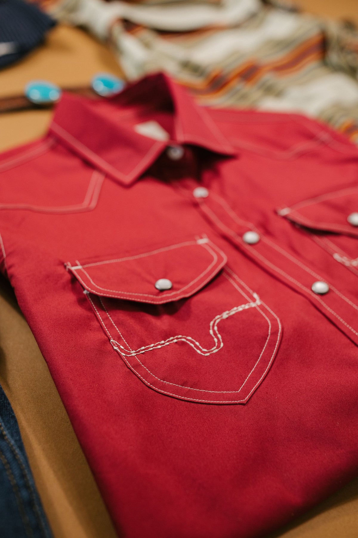 Kimes Ranch Skeeter top in Red, close-up, with contrast stitching and snap-button chest pockets