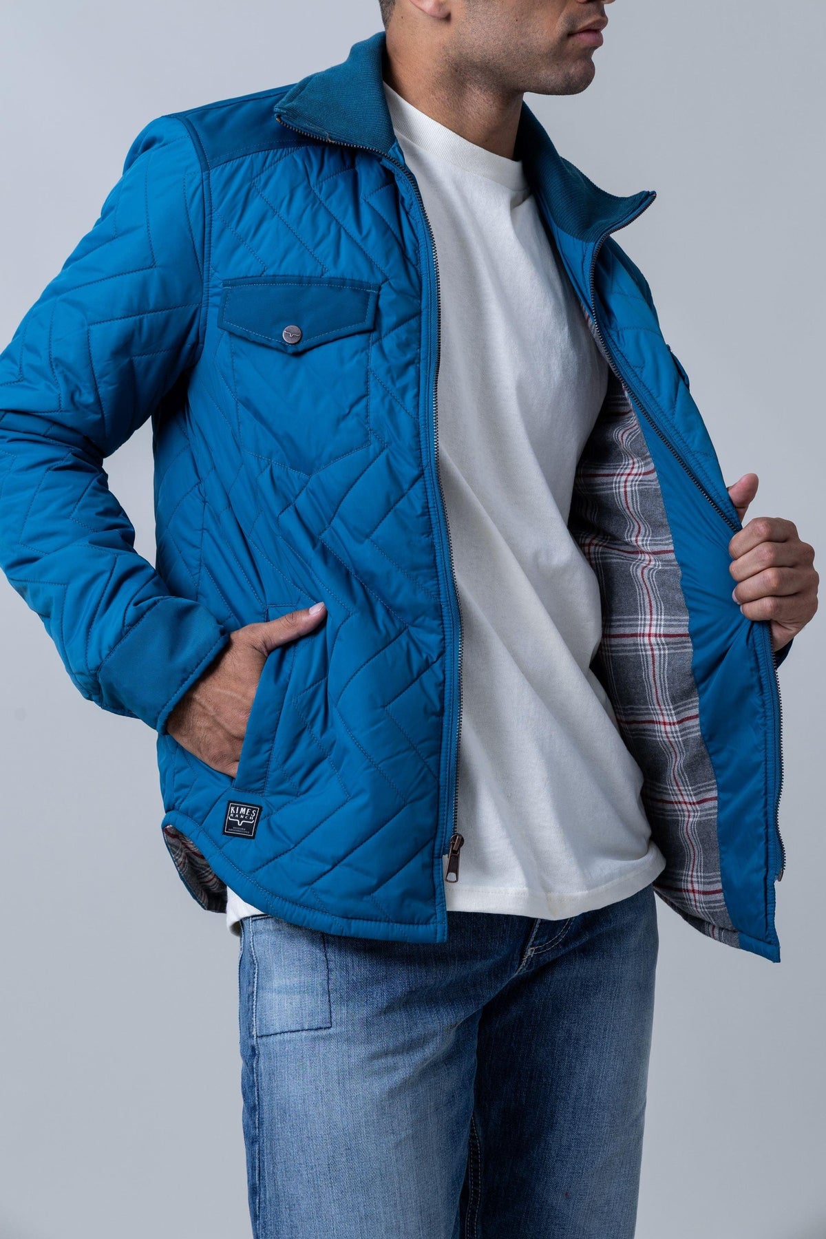 Kimes Ranch Skink Jacket in Mid Blue with diamond quilting, a buttoned chest pocket, and a plaid lining