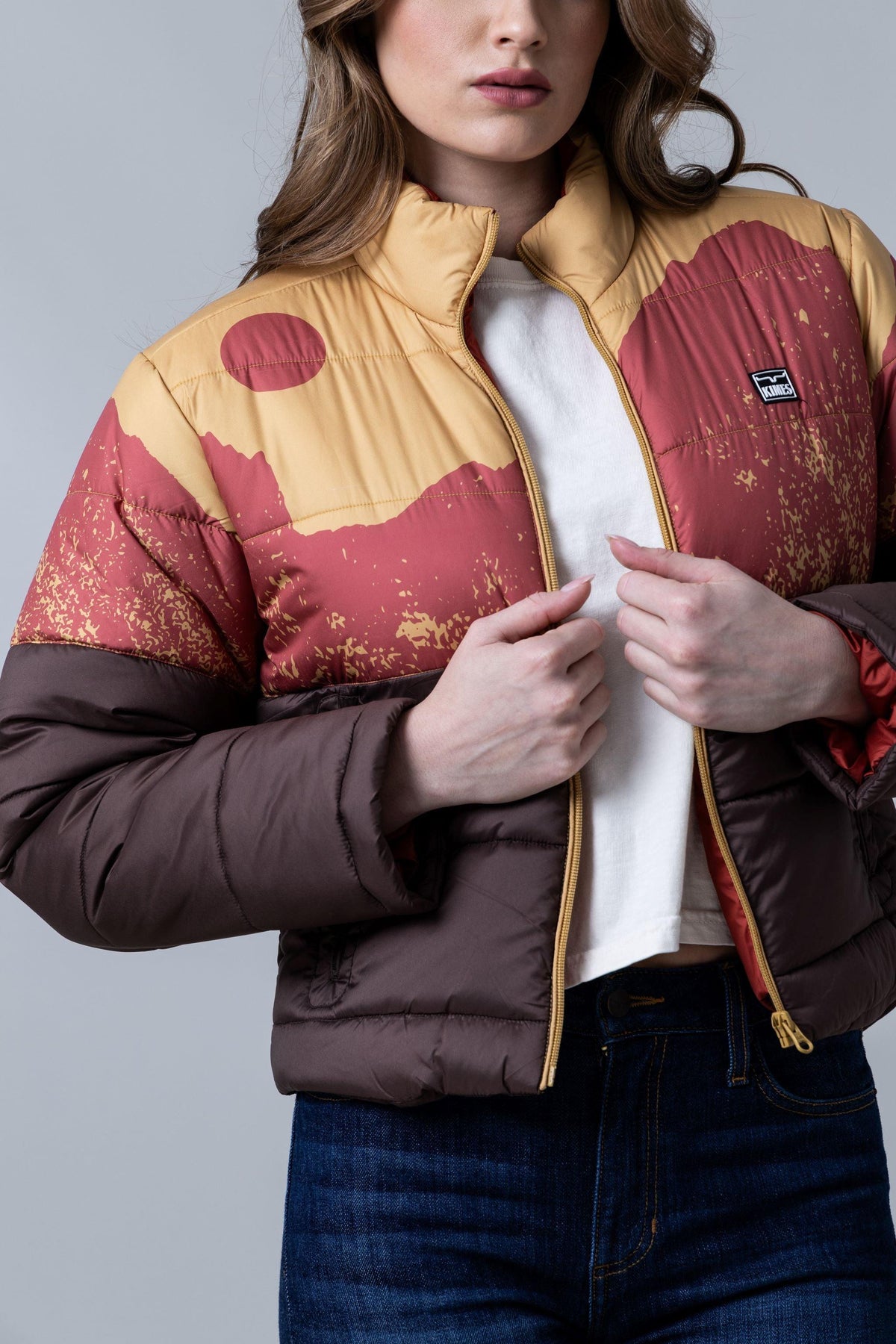Kimes Ranch Valencia Puffy jacket in Gold with a sunset landscape print and a Kimes Ranch logo patch