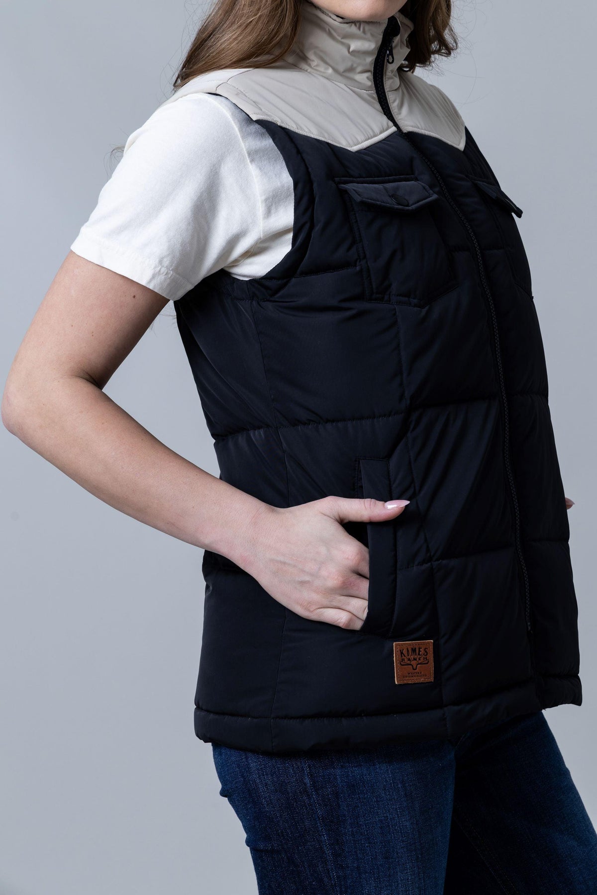 Kimes Ranch Wyldfire Vest in Black, side view, with a tan collar, chest pockets, and a logo patch