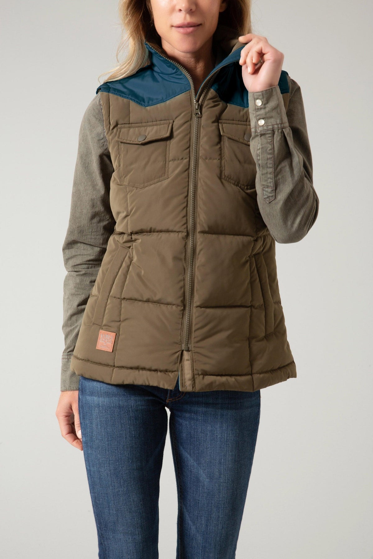 Kimes Ranch Wyldfire Vest in Army with teal collar, front pockets, and logo patch