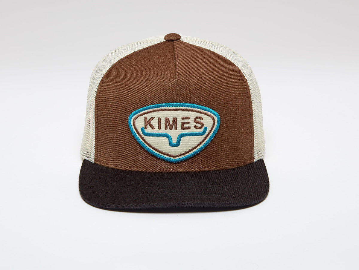 Kimes Ranch Conway Trucker Hat in brown with cream mesh and a blue embroidered logo patch