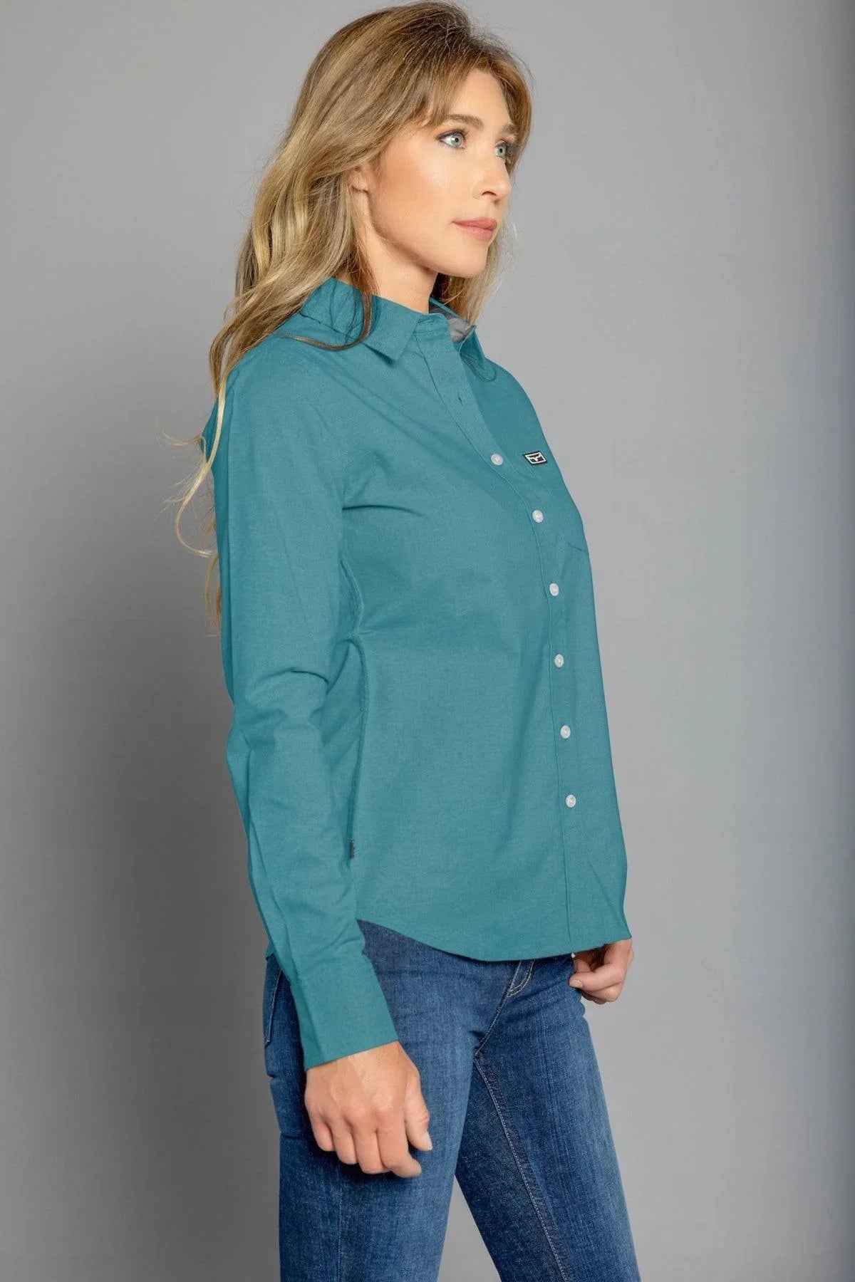 Kimes Ranch Ladies Linville long sleeve button-up top in Blue, side view, with a chest pocket and logo