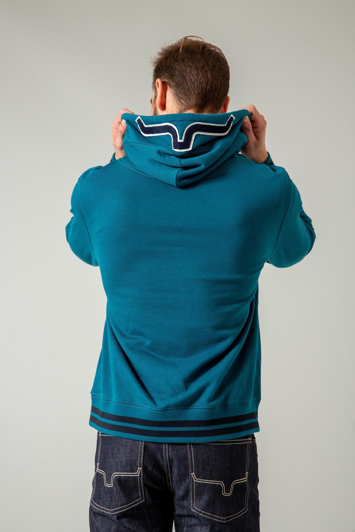 Kimes Ranch Team One Hoodie in Dark Blue, back view, with the Kimes Ranch logo on the hood and striped hem