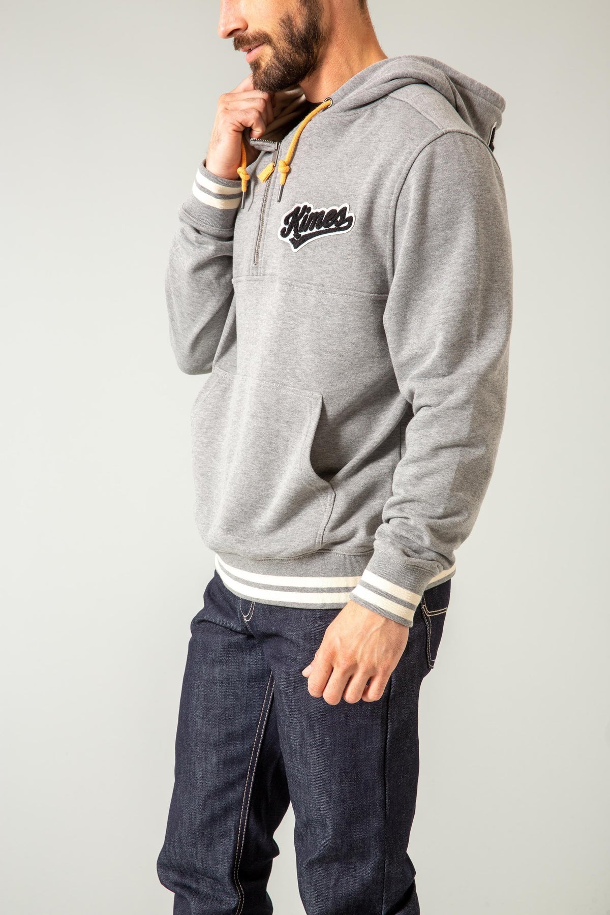 Kimes Ranch Team One Hoodie in Grey Heather, side view, with a front kangaroo pocket and striped cuffs